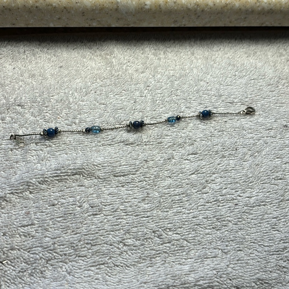 Silver tone and blue beaded bracelet with lobster claw clasp. 8” overall length.